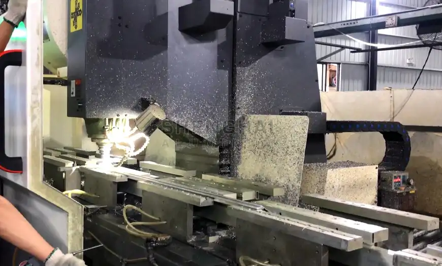 Precision CNC machining center cutting and drilling a custom aluminum profile with active coolant flow.