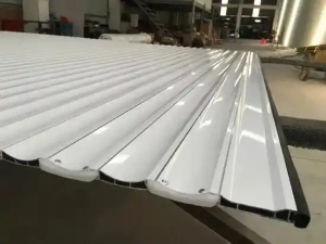 Close-up of white powder-coated double-walled aluminum roller shutter slats showing interlocking profile structure.